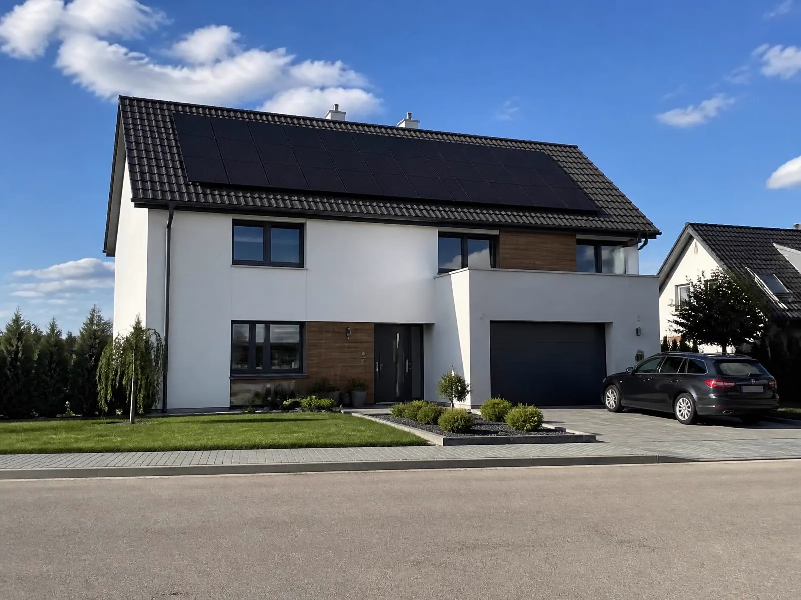Rodinný dom v prímestskej zástavbe s fotovoltaickými panelmi na sedlovej streche